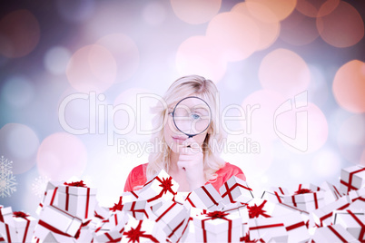 Composite image of fair-haired woman looking through a magnifyin