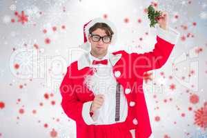Composite image of geeky hipster in santa costume holding mistle
