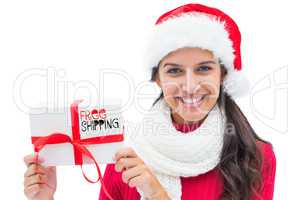 Composite image of festive brunette holding gift