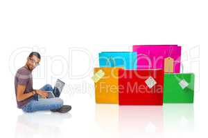 Composite image of man wearing glasses sitting on floor using la