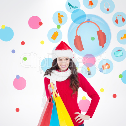 Composite image of brunette in winter clothes holding shopping b