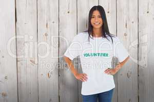 Composite image of cheerful woman wearing volunteer tshirt