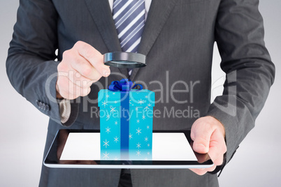 Composite image of businessman looking at tablet with magnifying Composite image of businessman looking at tablet with magnifying