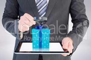 Composite image of businessman looking at tablet with magnifying