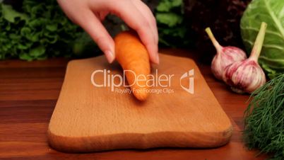 Female hands cut carrot