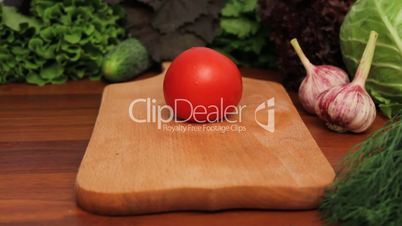 woman's hands cut tomato on a wooden board