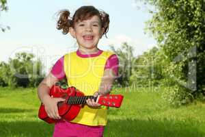 happy little girl play guitar and sing