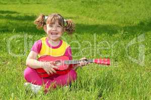 happy little girl play guitar outdoor