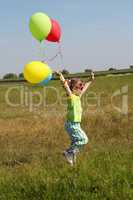 little girl running on field with balloons