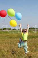 little girl with colorful balloons jumping