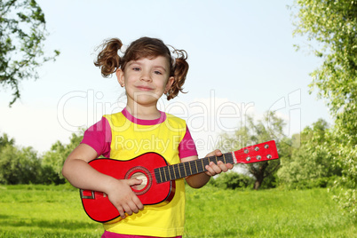 little girl with guitar in park