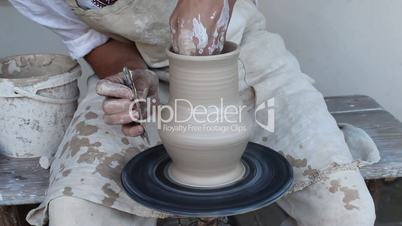 potter breaks a clay jug