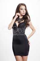 Young slim sexy woman in black dress isolated on white backgroun