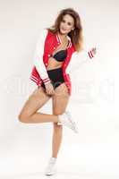 Beautiful young cheerleader in a red uniform