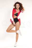 Beautiful young cheerleader in a red uniform