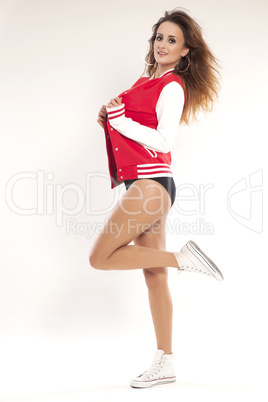 Beautiful young cheerleader in a red uniform