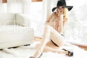 Young naked blonde posing with hat