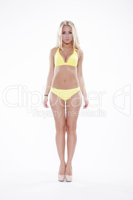 Sexy blonde woman wearing pink swimwear posing on white backgrou
