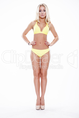 Sexy blonde woman wearing pink swimwear posing on white backgrou