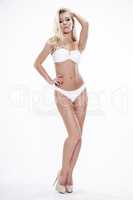 Sexy blonde woman wearing white swimwear posing on white backgro