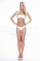 Sexy blonde woman wearing white swimwear posing on white backgro