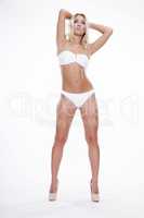 Sexy blonde woman wearing white swimwear posing on white backgro