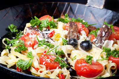 frische Pasta mit Tomaten und Oliven in einer Pfanne