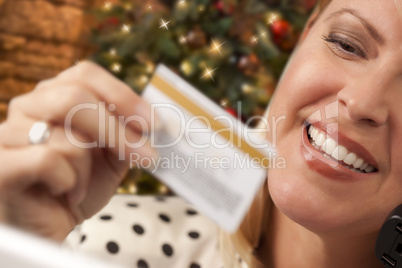 Phone Holding Woman Credit Card In Front of Christmas Tree