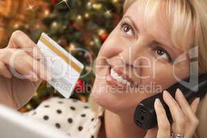 Phone Holding Woman Credit Card In Front of Christmas Tree