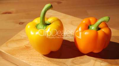 Two sweet peppers on a board