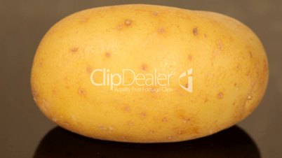 A ripe potato on a black pan closeup