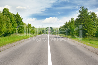 highway among green fields and blue sky