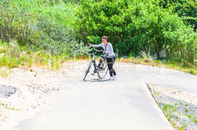 Junge Frau schieb ihr Fahrrad