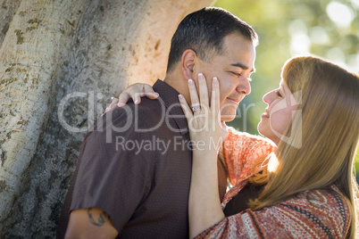 Mixed Race Couple Leaning Against Tree In a Romantic Moment