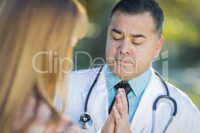 Hispanic Male Doctor Praying With A Patient