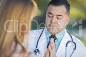 Hispanic Male Doctor Praying With A Patient