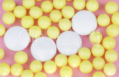 yellow vitamins on pink background