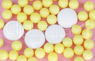 yellow vitamins on pink background