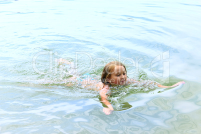 little girl swims in the river