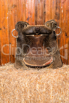 Old cowboy saddle on hay