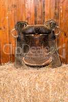 Old cowboy saddle on hay