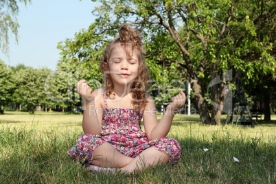 little girl meditates in nature