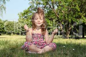 little girl meditates in nature