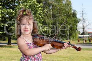 little girl play violin in park