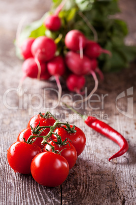 Tomaten, Chili und rote Radisches auf ein Holzbrett