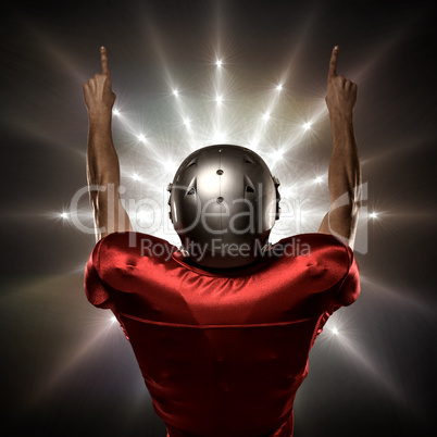 Composite image of rear view of american football player with arms raised