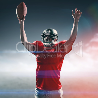 Composite image of american football player cheering while holding ball
