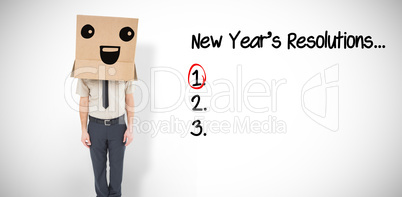 Composite image of businessman standing with box on head