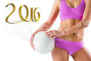 Composite image of fit girl in pink bikini holding ball