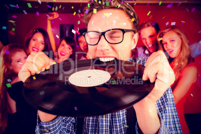 Composite image of geeky hipster biting vinyl record